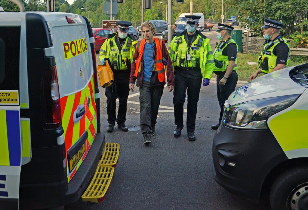 Officers lead a protester to a police van at a slip road at Junction 18 of the M25 (Steve Parsons/PA) (PA Wire)