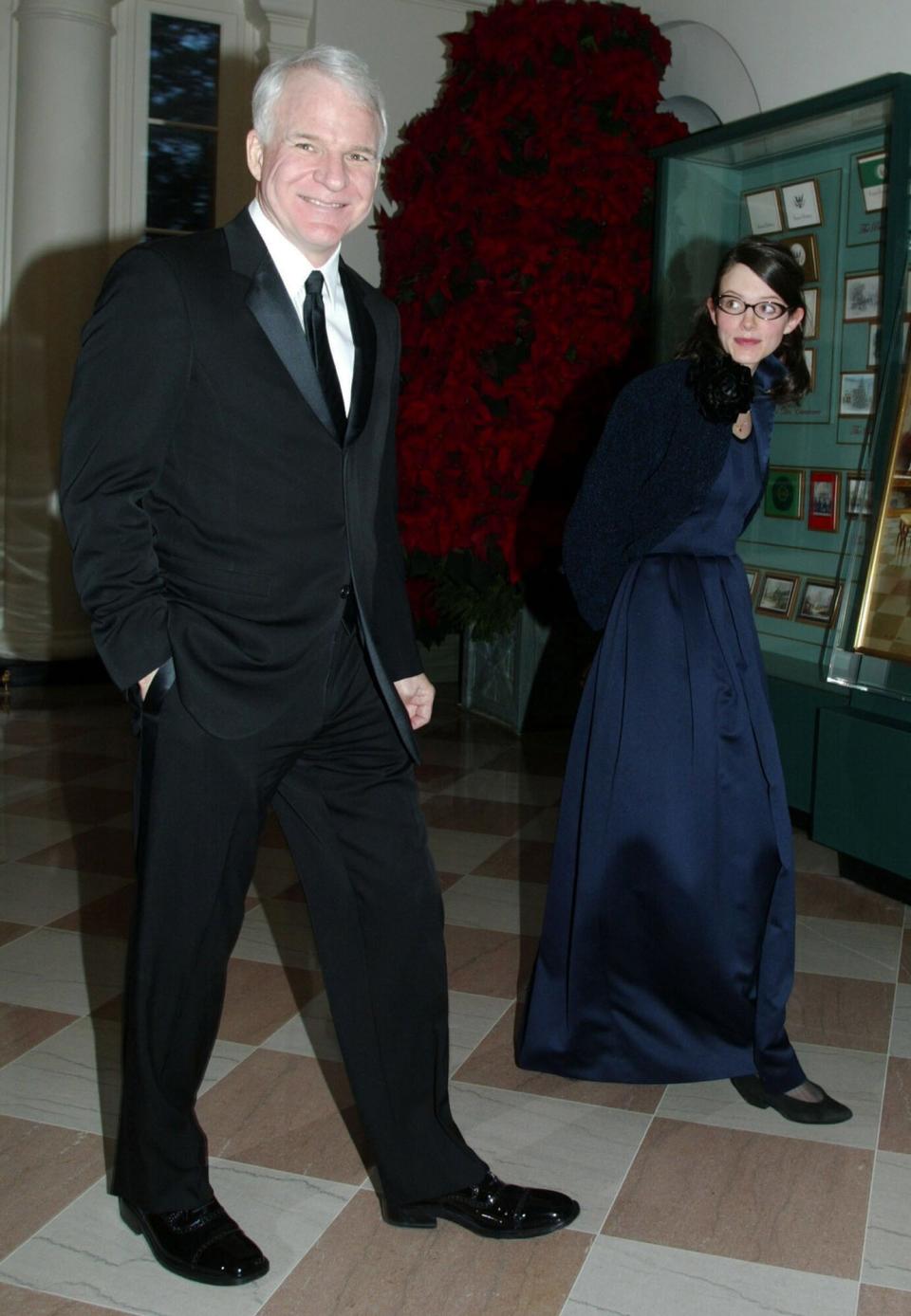 Steve Martin (L) arrives for a reception of the 2002 Kennedy Center Honors with his guest Anne Stringfield December 8, 2002 at the White House in Washington, D.C. The Kennedy Center selected five individuals, including actor James Earl Jones, conductor James Levine, musical theater actress Chita Rivera, singer Paul Simon and actress Elizabeth Taylor, to be the recipients of the 2002 Kennedy Center Honors for their contributions to the cultural life of the nation