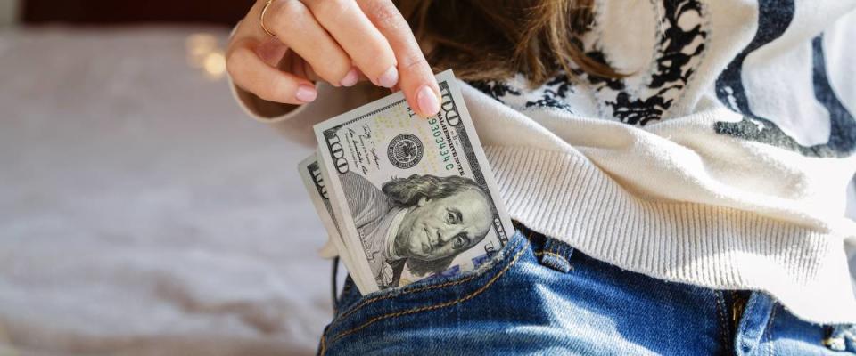 Woman putting cash in pocket