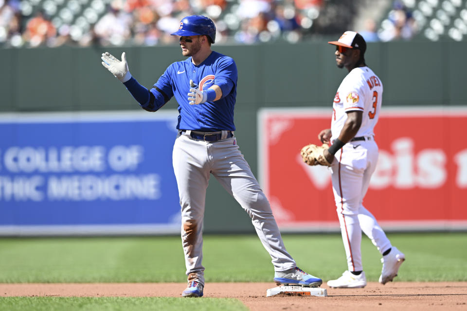 Chicago Cubs' Ian Happ, left, reacts after hitting a double against the Baltimore Orioles in the fourth inning of a baseball game, Thursday, Aug. 18, 2022, in Baltimore. (AP Photo/Gail Burton)