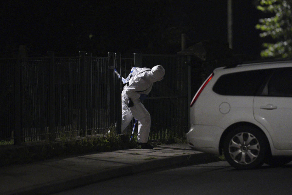 An officer in a forensics suit near the scene of an incident in the Keyham area of Plymouth, southwest England, Thursday, Aug. 12, 2021. Police in southwest England said several people were killed, including the suspected shooter, in the city of Plymouth Thursday in a “serious firearms incident” that wasn't terror-related. (Ben Birchall/PA via AP)