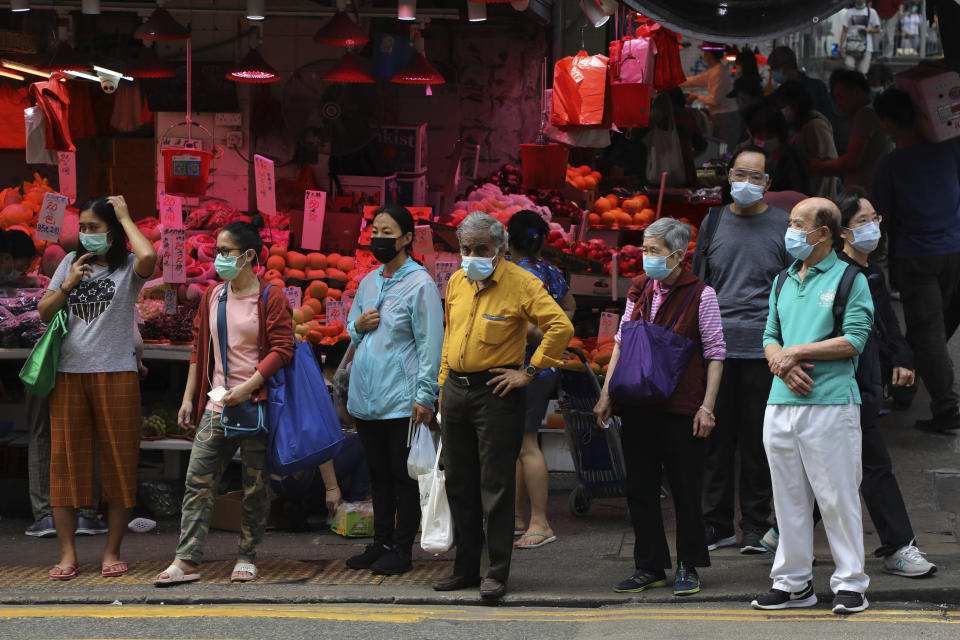 People wearing face masks to help protect themselves from contracting the coronavirus COVID-19 as they cross a street in Hong Kong, Saturday, April 18, 2020. (AP Photo/Kin Cheung)