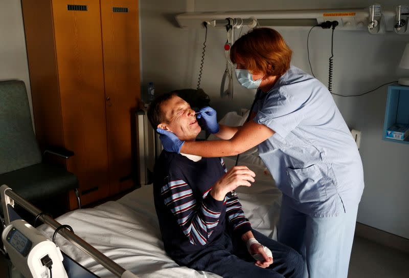 Foto del martes de la médica belga Elisabeth Lenoir tomando una muestra a un indigente para hacerle la prueba de coronavirus en un hospital cerca de Arlon, en Bélgica