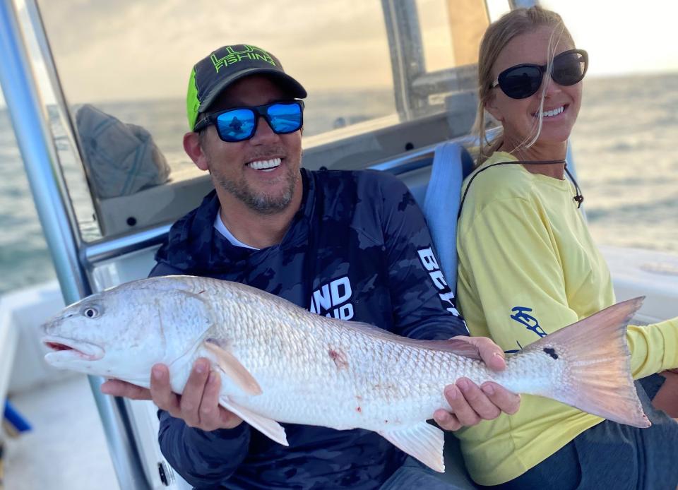 Travis and Angie Doseck with an over-slot redfish they caught (and released) aboard Capt. Jeff Patterson's Pole Dancer.