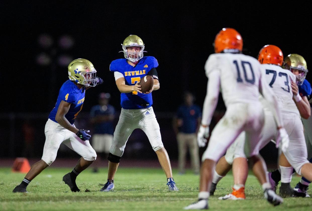 Cardinal Newman quarterback Luke Warnock hands the ball to running back Jaylin Brown against Benjamin during their football game on October 20, 2023 in West Palm Beach, Florida.