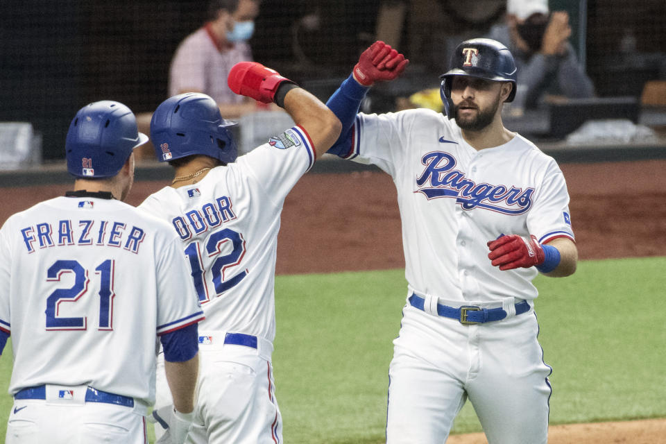 Texas Rangers' Joey Gallo, right, is congratulated by Rougned Odor (12) and Todd Frazier (21) after hitting a two run home run off of Arizona Diamondbacks relief pitcher Andrew Chafin that scored Odor during the eighth inning of a baseball game Wednesday, July 29, 2020, in Arlington, Texas. Texas won 7-4. (AP Photo/Jeffrey McWhorter)