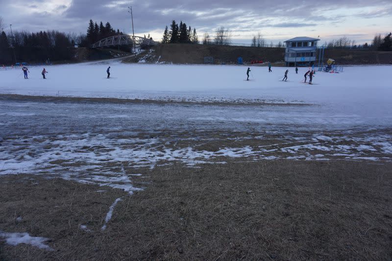 High-school cross-country ski team members practice on a small loop of manmade snow, after winter warmth and rains erased the natural snows at Kincaid Park in Anchorage, Alaska