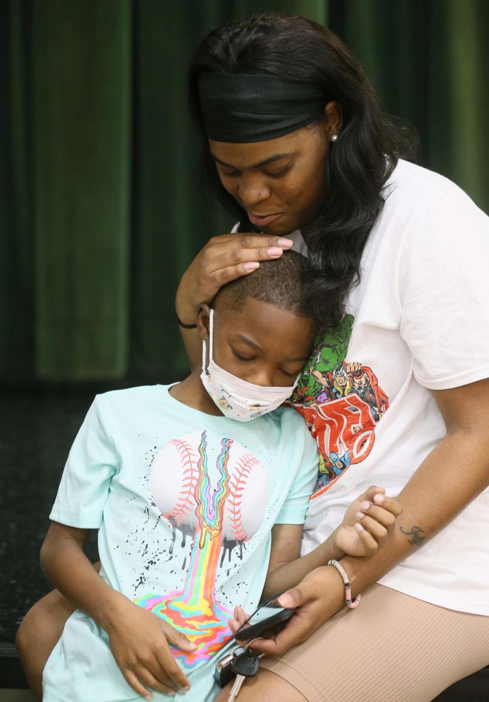 Tyren Thompson, 7, rests with his mother, Jazmere Stephens, during a visit to Helen Arnold Community Learning Center in Akron.