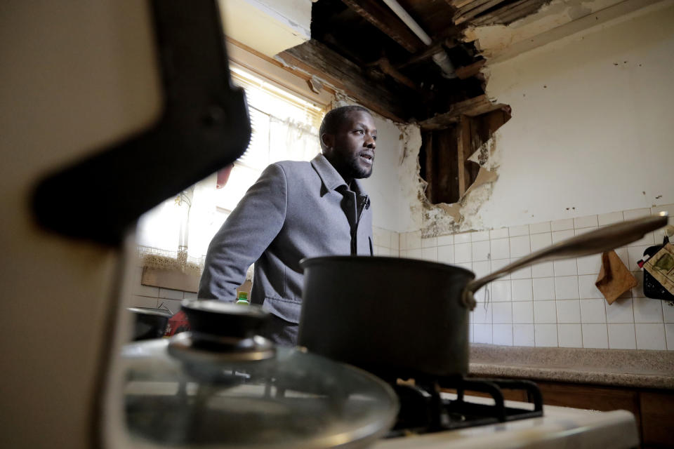 FILE- In this Nov. 8, 2018 file photo, a hole is seen on the wall and ceiling in Desmond Odom's kitchen as he talks to The Associated Press about the lead in his tap water in Newark, N.J. A water leak forced Odom to hire a contractor and pay $2,000 to replace a lead pipe that burst, but he claims he and his family have stopped drinking the tap water because of the lead pipes in his home. New Jersey's biggest city has recently been the epicenter of a problem with lead in drinking water, but the United States has an estimated 6 million lead pipes, many of them in unknown locations. (AP Photo/Julio Cortez, File)