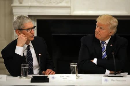 U.S. President Donald Trump listens as Tim Cook, CEO of Apple speaks during an American Technology Council roundtable at the White House in Washington, U.S., June 19, 2017. REUTERS/Carlos Barria/Files