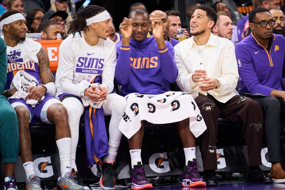 (L-R) Phoenix Suns guard Damion Lee, Bismack Biyombo and Devin Booker, react to a three-pointer against the Washington Wizards at Footprint Center on Tuesday, Dec. 20, 2022.