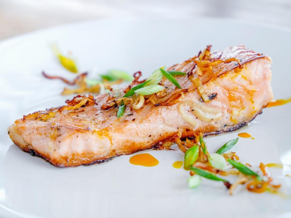 A plated piece of salmon on a white plate