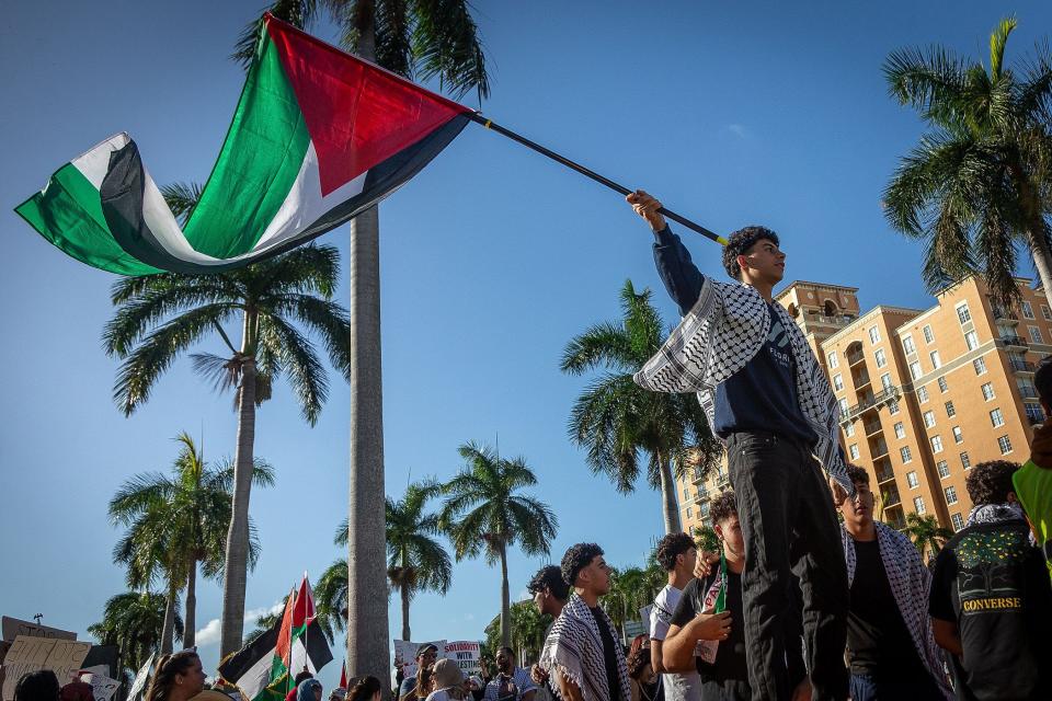 Sadiq Ali, of Boca Raton, waves his flag during a Palestinian rally Sunday in West Palm Beach.