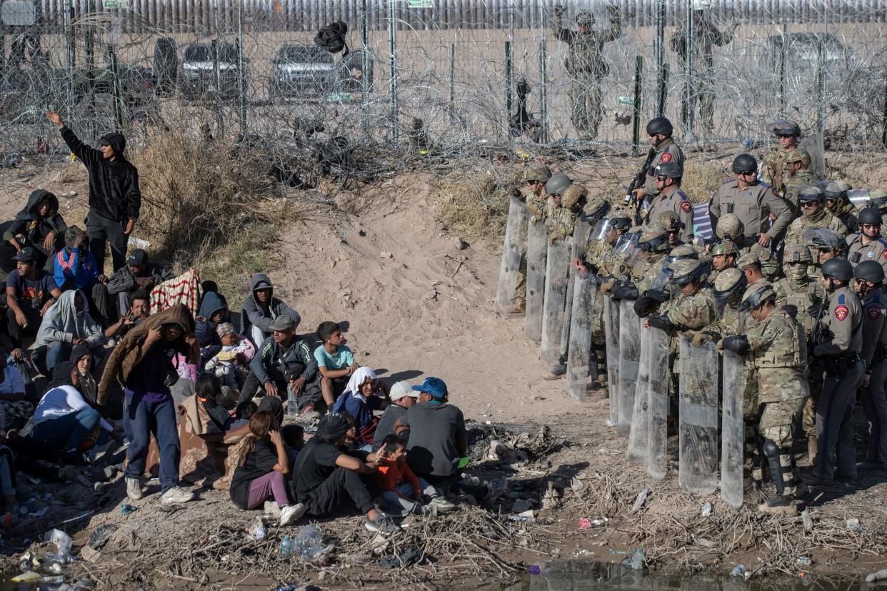 Texas National Guard and Texas State Troopers use anti-riot gear to prevent asylum seekers from entering further into U.S. territory after the migrants crossed the Rio Grande into El Paso, Texas from Ciudad Juarez, Mexico on March 22, 2024.