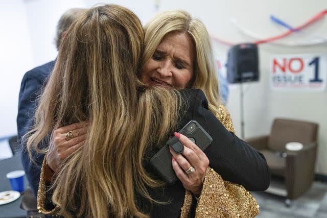 <p>AP Photo/Carolyn Kaster</p> Two opponents to Issue 1 hug after hearing the proposal had passed