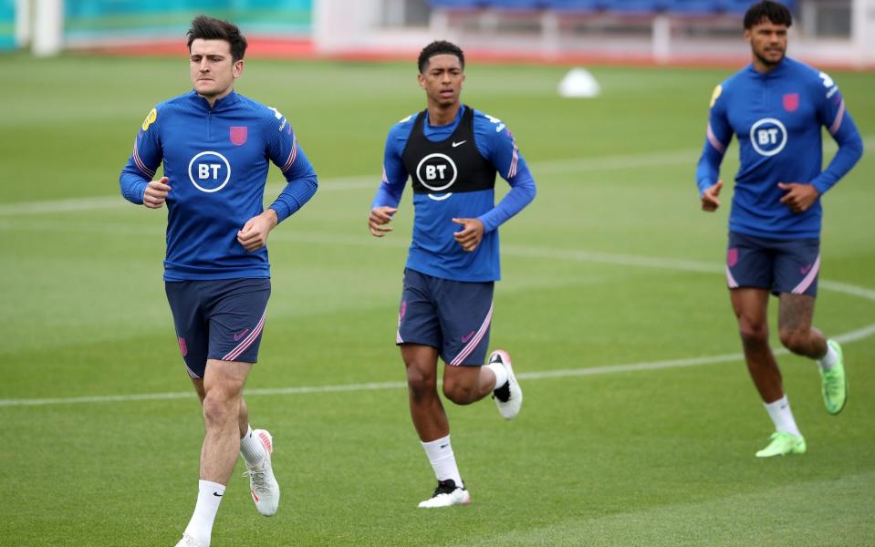 Harry Maguire, Jude Bellingham and Tyrone Mings warm up ahead of training - PA