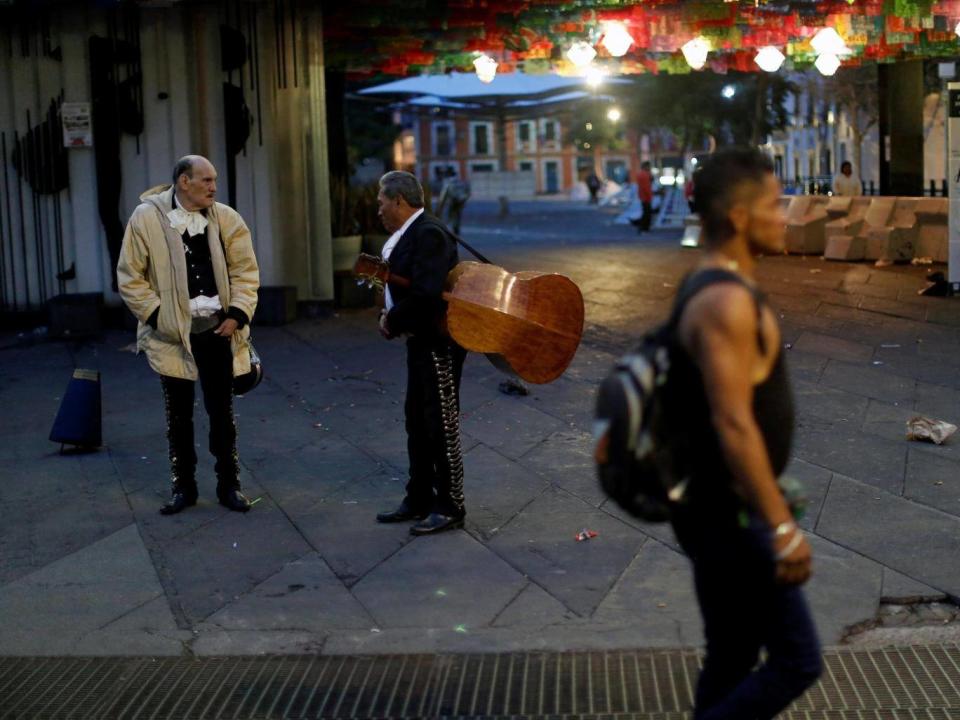 Mariachi musicians talk at the tourist Plaza Garibaldi hours after unknown assailants attacked people with rifles and pistols (Reuters)