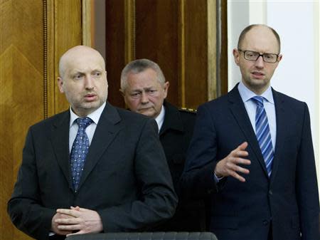 Ukrainian acting President Oleksander Turchinov (L), Prime Minister Arseny Yatseniuk (R) and acting Defence Minister Ihor Tenyuk enter a hall to take part in a conference call with commanders of Ukrainian military units, located in Crimea, at the Defence Ministry headquarters in Kiev, March 18, 2014. REUTERS/Mykhailo Markiv/Ukrainian Presidential Press Service/Handout via Reuters