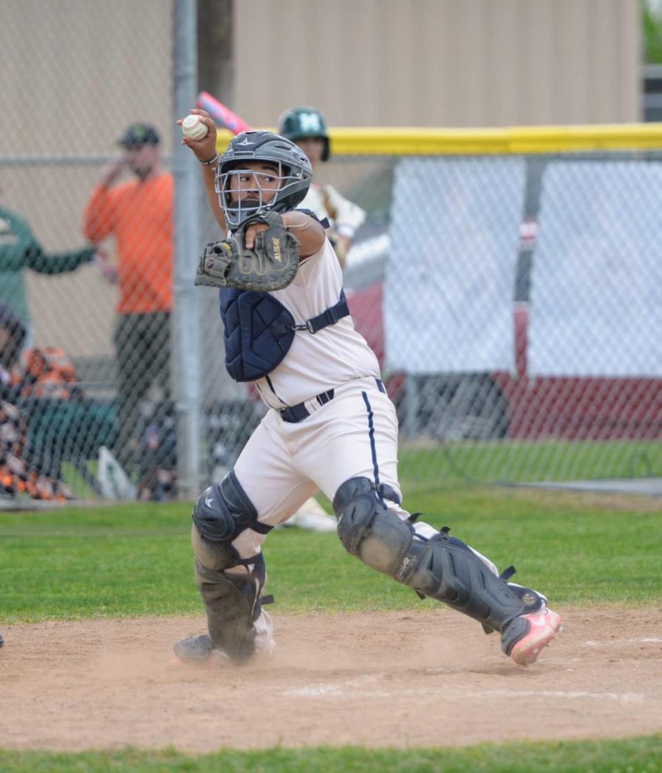 Central Catholic catcher Frenando Alaniz attempts to throw out a runner at first base during a Valley Oak League matchup with Manteca at Manteca High School on Friday, April 26, 2024.