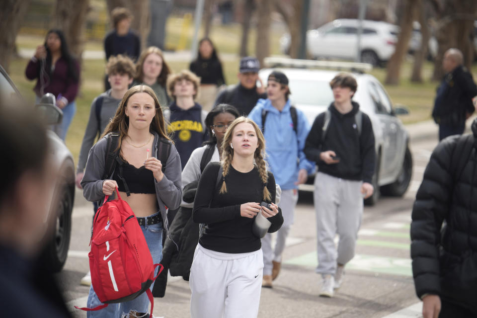 Students are walked out of East High School following a shooting, Wednesday, March 22, 2023, in Denver. Authorities say two school administrators were shot and wounded after a handgun was found during a daily search of a student at a Denver high school. The suspect remained at large. (AP Photo/David Zalubowski)