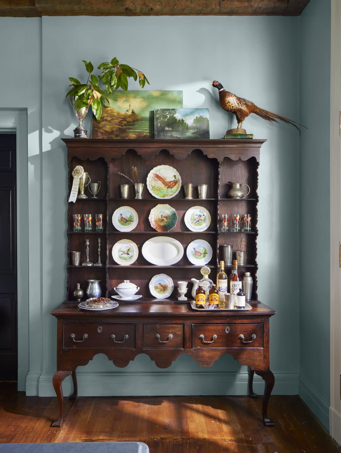hutch with china and stuffed birds on top