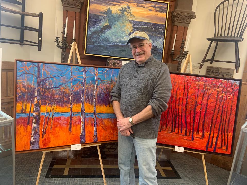 Mark Lore with some of the paintings on display at the Gardner Museum as part of the artist's exhibit, "The First 50 Years."