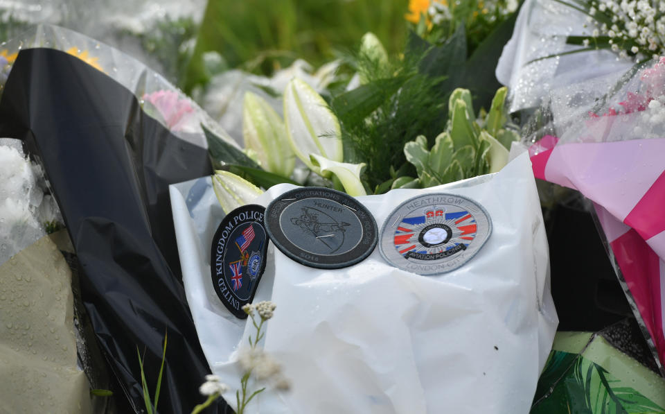 Badges on floral tributes at the scene, where Thames Valley Police officer Pc Andrew Harper, 28, died following a "serious incident" at about 11.30pm on Thursday near the A4 Bath Road, between Reading and Newbury, at the village of Sulhamstead in Berkshire.