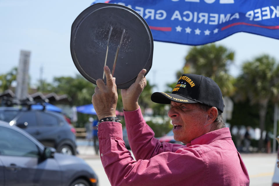 A supporter of former President Donald Trump bangs on a pizza pan at a rally, Monday, April 3, 2023, in West Palm Beach, Fla. (AP Photo/Wilfredo Lee)