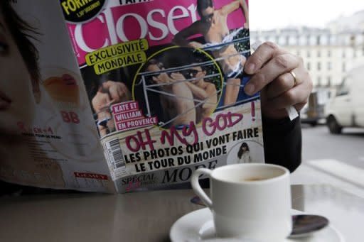 Un hombre lee el número de la revista francesa Closer que publica las fotos en toples de la duquesa Catalina de Cambridge, esposa del príncipe Guillermo de Inglaterra, este viernes en un café de París. (AFP | Kenzo Tribouillard)