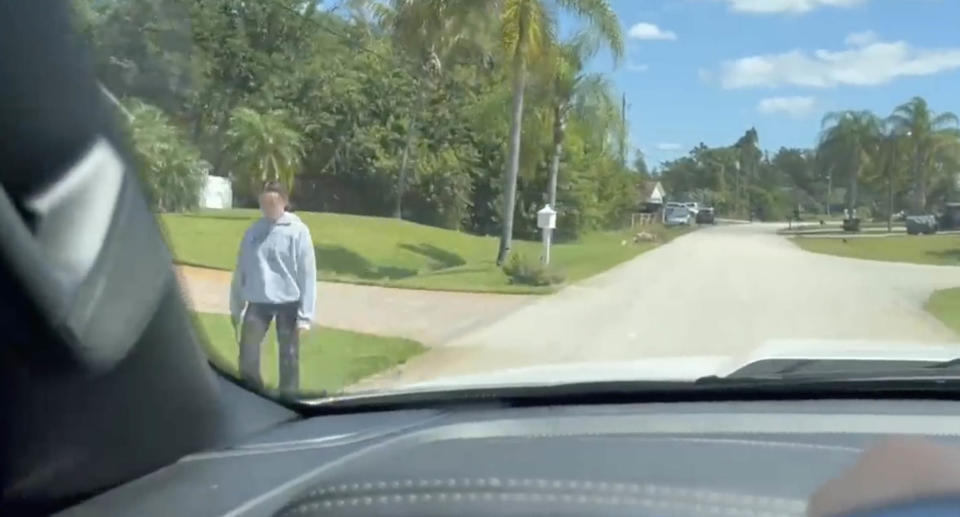 Dashcam footage showing a young woman walking on the side of the road.