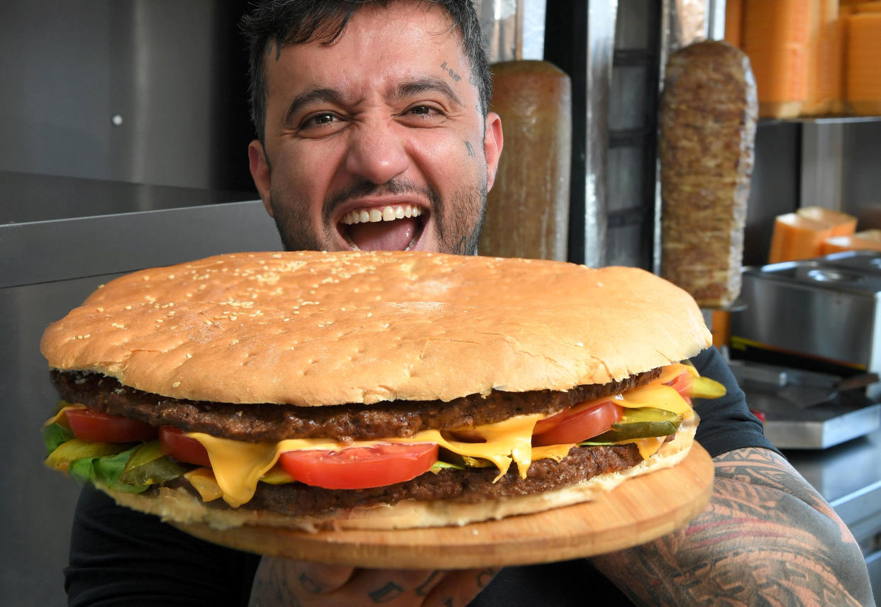 Yunus Sevinik with the massive 14" burger. (SWNS)