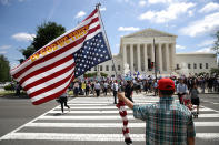 <p>A man bearing an upside down American flag watches as protesters gather outside the U.S. Supreme Court as the court issued an immigration ruling June 26, 2018 in Washington, D.C. (Photo by Win McNamee/Getty Images) </p>