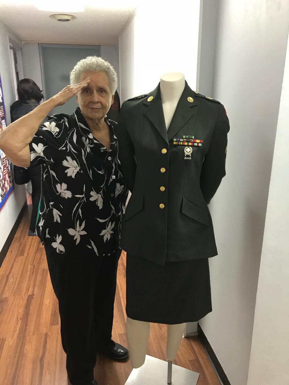 U.S. Army veteran Ruth Young, whose duty included the Vietnam War, salutes next to the uniform she would have worn on display at the Northeast Florida Women Veterans office in Jacksonville. This is one of the uniforms on display at City Hall next week.