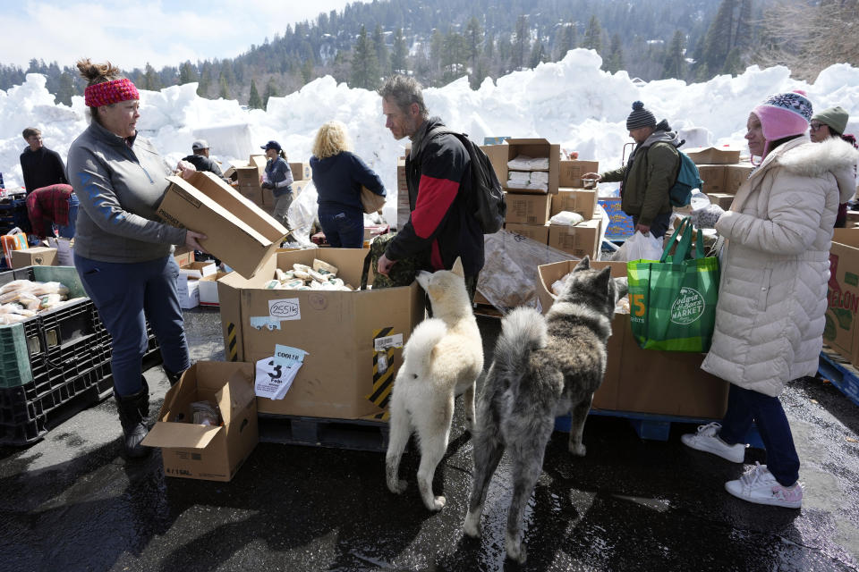 Food is distributed out of a parking lot after a series of storms, Wednesday, March 8, 2023, in Crestline, Calif. (AP Photo/Marcio Jose Sanchez)