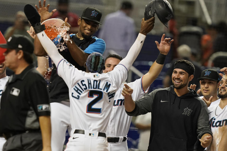 Florida Marlins players celebrate after Jazz Chisholm Jr. (2) scored the winning run during the 10th inning of a baseball game against the Washington Nationals, Monday, Sept. 20, 2021, in Miami. (AP Photo/Marta Lavandier)