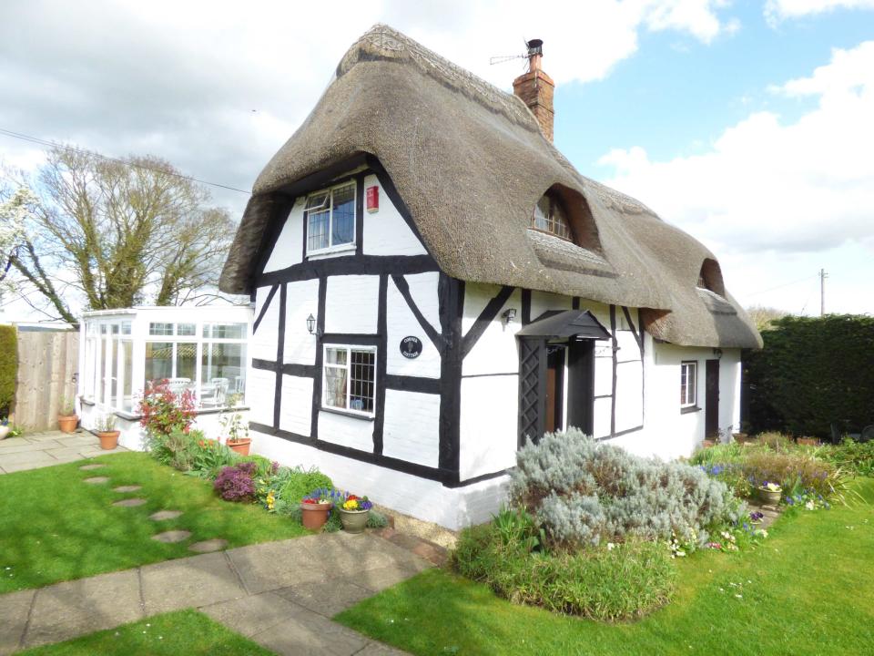 <p>Perhaps a little different to the quintessential Cotswold-stone cottages but no less striking, this three-bedroom home is set in pretty gardens, overlooking beautiful countryside. Notable features are the exposed timbers and stone walls, inglenook fireplace, log burning stove, original bread oven and conservatory with French doors leading to the terrace. </p><p><em>This property is available for £595,000 through <a rel="nofollow noopener" href="https://www.onthemarket.com/details/3667780/" target="_blank" data-ylk="slk:OnTheMarket.com;elm:context_link;itc:0;sec:content-canvas" class="link ">OnTheMarket.com</a>. </em></p>