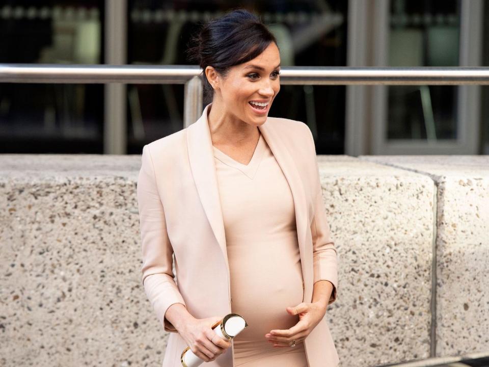 Meghan Markle, pregnant and wearing a peach-colored outfit, in 2019.