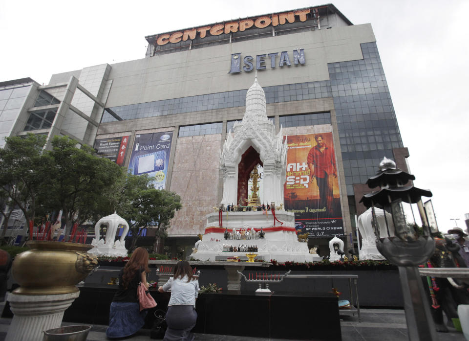 In this photo taken Friday, June 15, 2012, women prays to Buddhist statues in front of a shopping mall in Bangkok, Thailand. There was a time when Buddhist pilgrims would journey thousands of miles on foot to seek enlightenment, what is known to the faithful as "dharma." Last week, anyone looking for a taste of enlightenment could make one's way to a modern mega-mall in downtown Bangkok to grab a seat in a modern air-conditioned movie theater. Some promoters brought 36 films with Buddhist themes to the heart of modern Thailand earlier this month. (AP Photo/Sakchai Lalit)