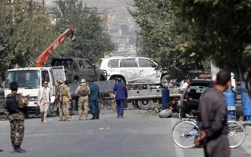 Afghan security personnel move damaged vehicles belonging to a vice president convoy targeted by an explosion in Kabul, Afghanistan, Wednesday, Sept. 9, 2020. Spokesman for Afghanistan's Interior Ministry said the bombing that targeted the convoy of the country's first vice president on Wednesday morning killed several people and wounded more than a dozen others, including several of the vice president's bodyguards. (AP Photo/Rahmat Gul)