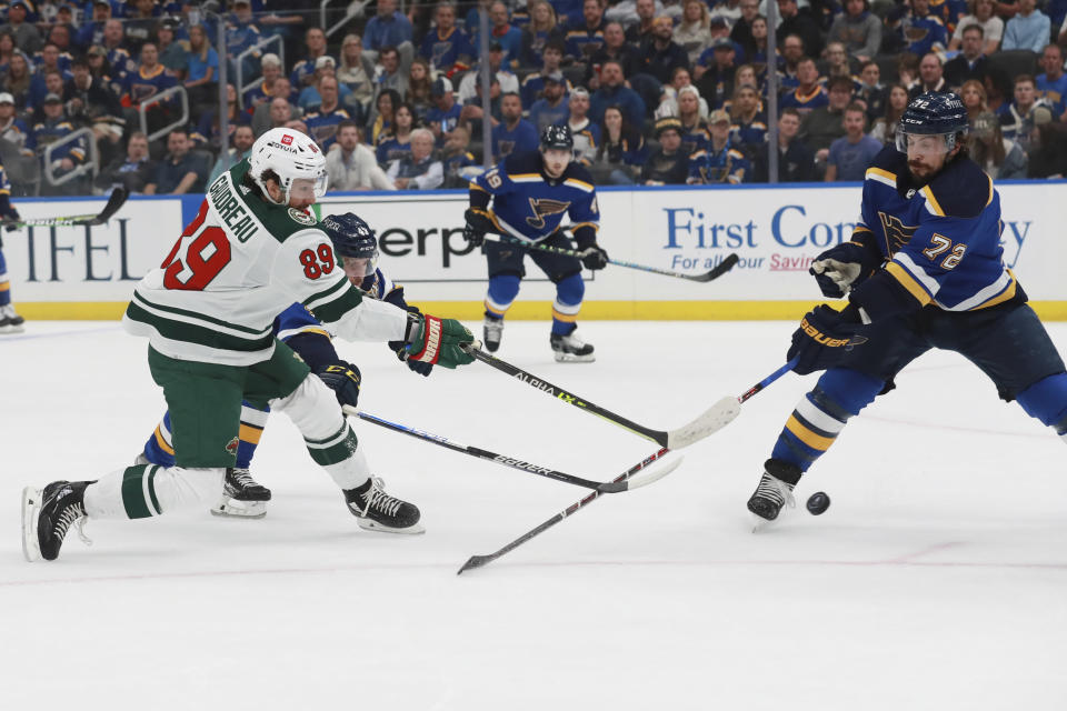 Minnesota Wild's Frederick Gaudreau (89) shoots the puck against St. Louis Blues' Justin Faulk (72) during the first period in Game 6 of an NHL hockey Stanley Cup first-round playoff series Thursday, May 12, 2022, in St. Louis. (AP Photo/Michael Thomas)