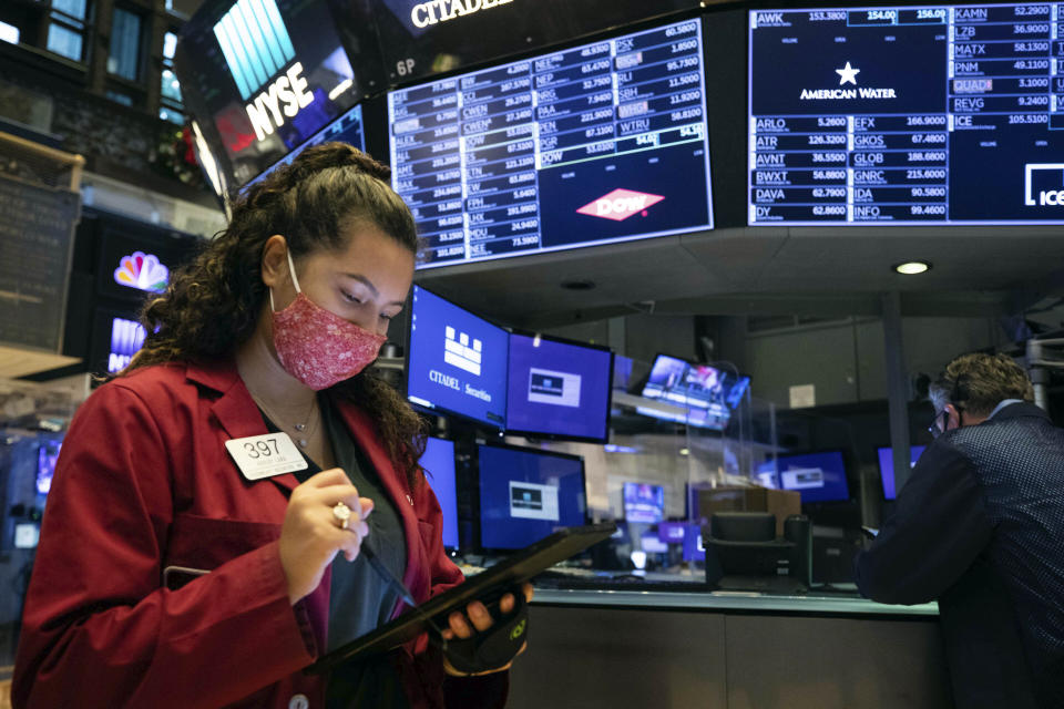 In this photo provided by the New York Stock Exchange, trader Ashley Lara uses her handheld device as she works on the trading floor, Tuesday, Dec. 1, 2020. U.S. stocks rose broadly in morning trading Tuesday, sending the S&P 500 toward another record high, as investors focus on the possibility that coronavirus vaccines could soon help usher in a fuller global economic recovery. (Colin Ziemer/New York Stock Exchange via AP)