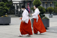 Shrine maidens walk in the compound of Kanda shrine in Tokyo Friday, May 15, 2020. Tokyo is still under a coronavirus state of emergency until the end of May, though there have been no hard lockdowns. (AP Photo/Eugene Hoshiko)