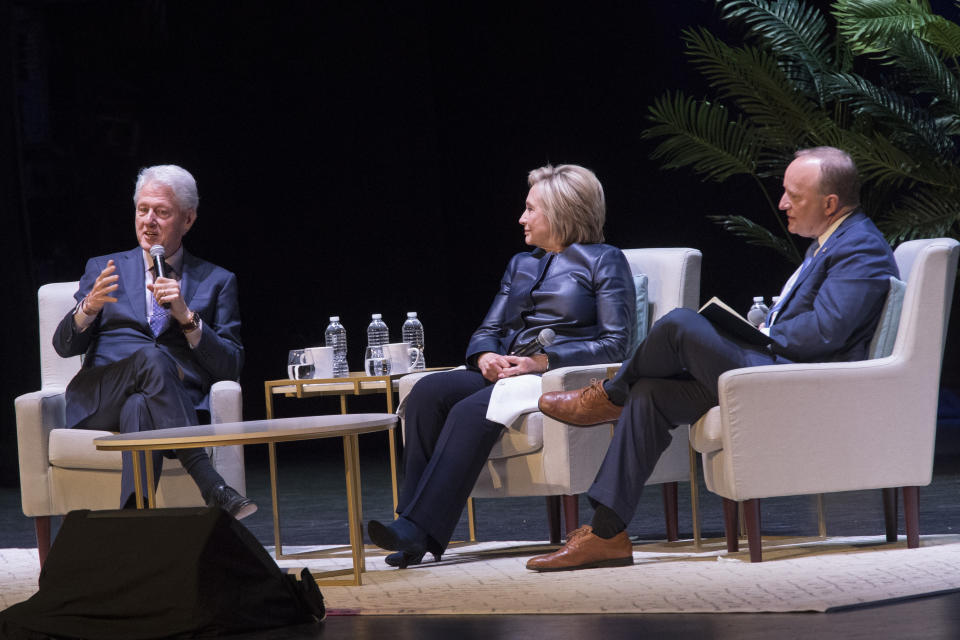 Paul Begala, right, and former Secretary of State Hillary Rodham Clinton, center, listen as former President Bill Clinton speaks during "An Evening with the Clintons", Thursday, April 11, 2019, at the Beacon Theatre in New York. (AP Photo/Mary Altaffer)