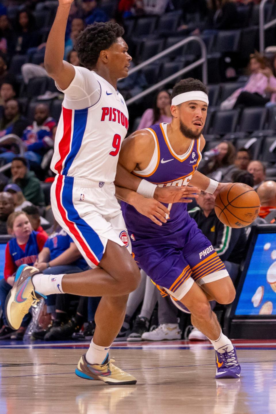 Detroit Pistons forward Ausar Thompson defends Phoenix Suns guard Devin Booker during the first half of a preseason game at Little Caesars Arena, Oct. 8, 2023.