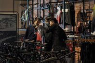 A man wearing a face mask to help curb the spread of the coronavirus checks on a cycling cloth with his friend at a bicycle retail shop selling American bicycle brand in Beijing on Tuesday, March 2, 2021. Chinese leaders are shifting focus from the coronavirus back to long-term goals of making China a technology leader at this year's highest-profile political event, the meeting of its ceremonial legislature, amid tension with Washington and Europe over trade, Hong Kong and human rights. (AP Photo/Andy Wong)