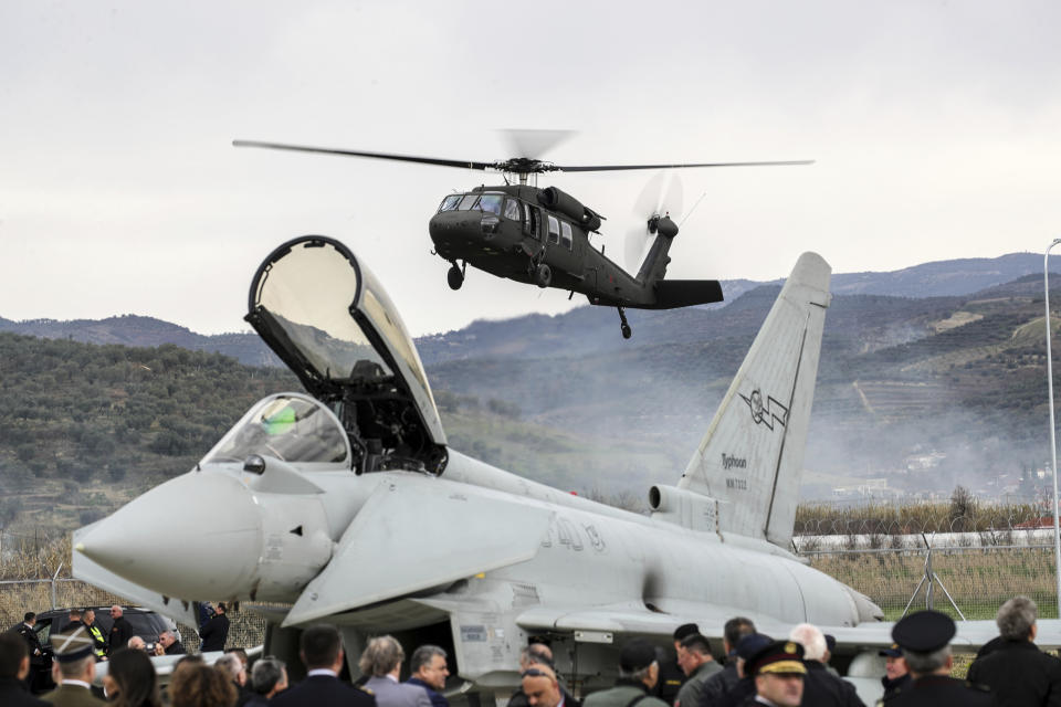 A military helicopter lands near an Italian Eurofighter at an airbase during a ceremony, in Kocuve, about 85 kilometers (52 miles) south of Tirana, Albania, Monday, March 4, 2024. NATO member Albania inaugurated an international tactic air base on Monday, the Alliance's first one in the Western Balkan region. (AP Photo/Armando Babani)