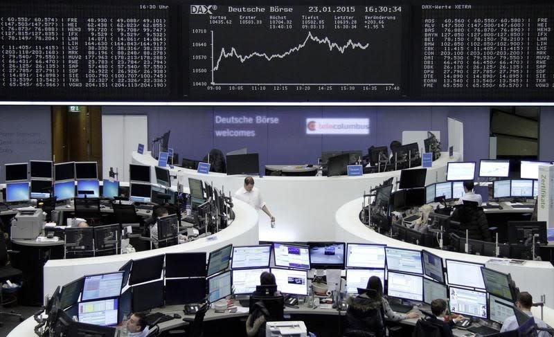 Traders work at their screens in front of the German share price index DAX board at the stock exchange in Frankfurt January 23, 2015. REUTERS/Pawel Kopczynski/remote