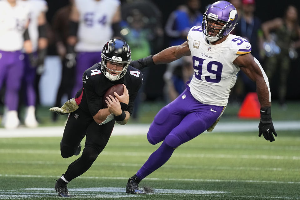 Atlanta Falcons quarterback Taylor Heinicke (4) runs for a first down past Minnesota Vikings linebacker Danielle Hunter (99) during the second half of an NFL football game, Sunday, Nov. 5, 2023, in Atlanta. (AP Photo/John Bazemore)