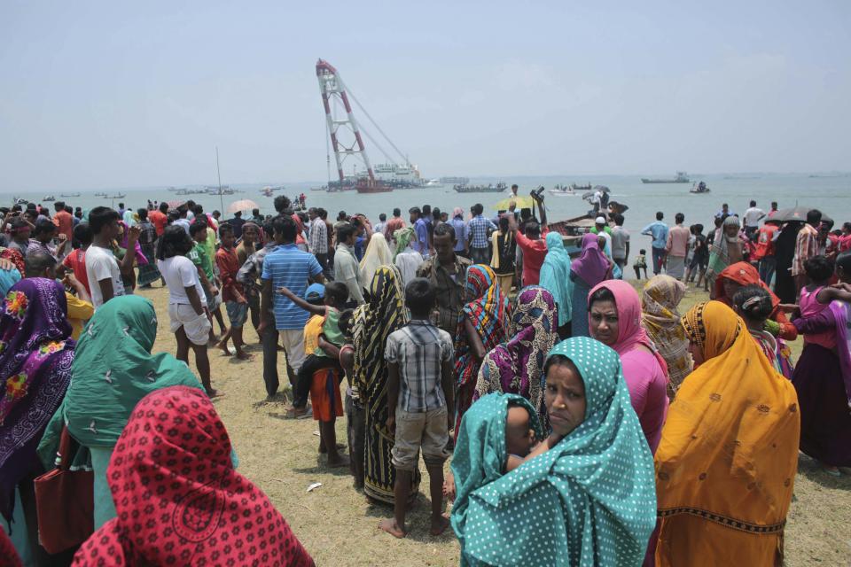 Relatives wait as they watch the rescue operation after the M.V. Miraj-4 ferry capsized, by the Meghna river at Rasulpur in Munshiganj district May 16, 2014. (REUTERS/Andrew Biraj)