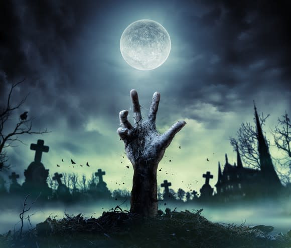 A zombie hand reaches out from the grave.